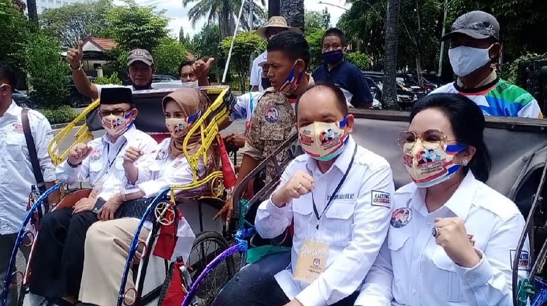 FOTO: Bapaslon Ben-Ujang didampingi istri, didampingi tim pemenangannya, menaiki Becak Kayuh menuju kantor KPU Kalimantan Tengah, untuk mendaftar keikutsertaannya dalam PILKADA tahun 2020. Pendaftaran dilakukan di KPU Kalteng, pada hari Sabtu (5/9/2020).